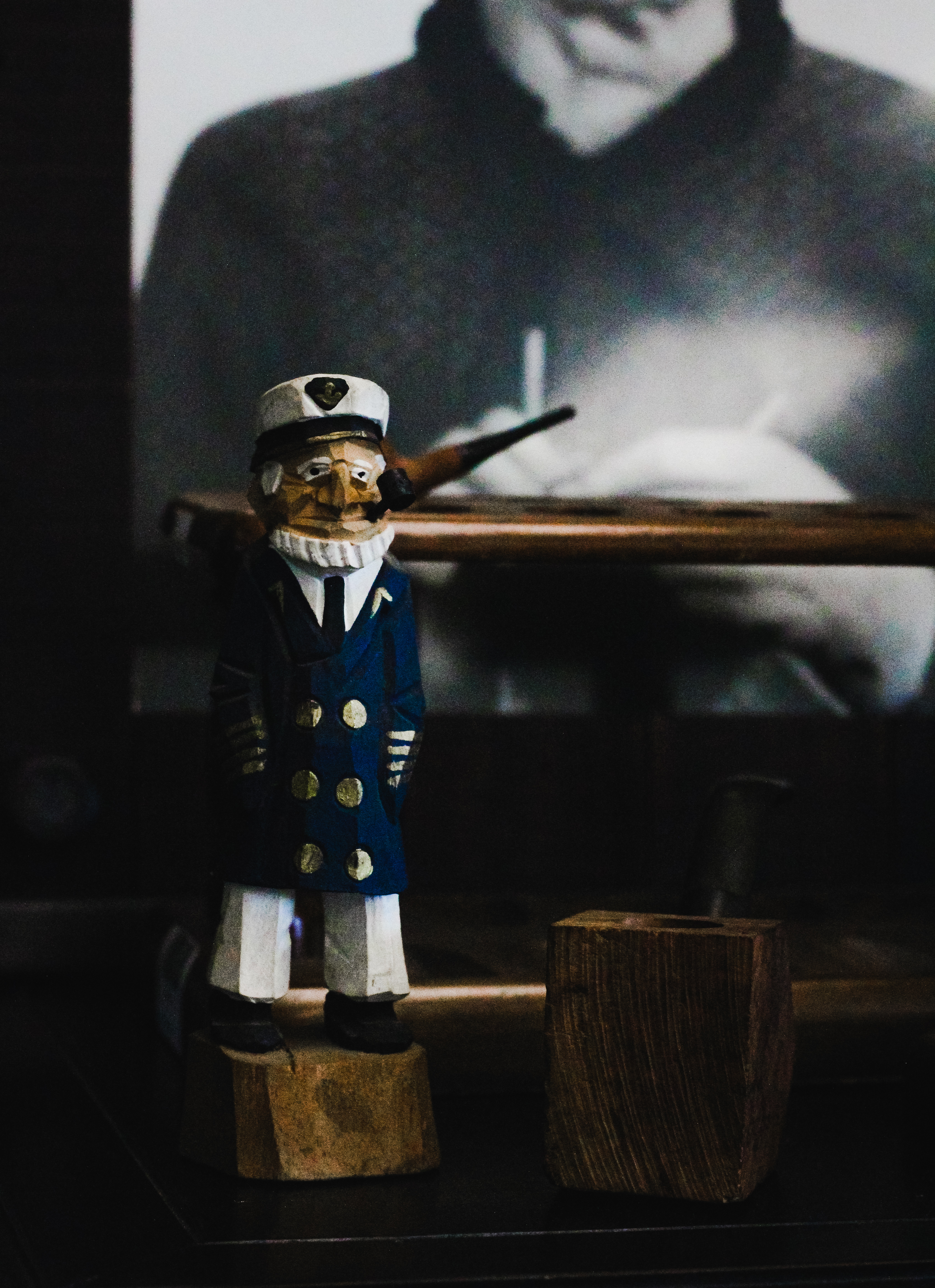 sailor smoking wood figurine, black and white portrait, cigar lounge, moody lighting